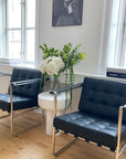 Eksklusiv design loungestol i sort læder med stålstel og armlæn
